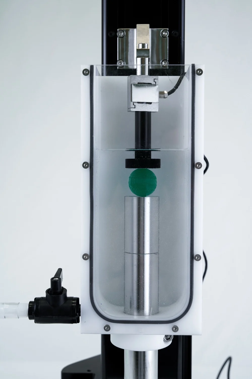 The UniVert uniaxial mechanical testing system setup with a vertical media bath, compression testing a ball