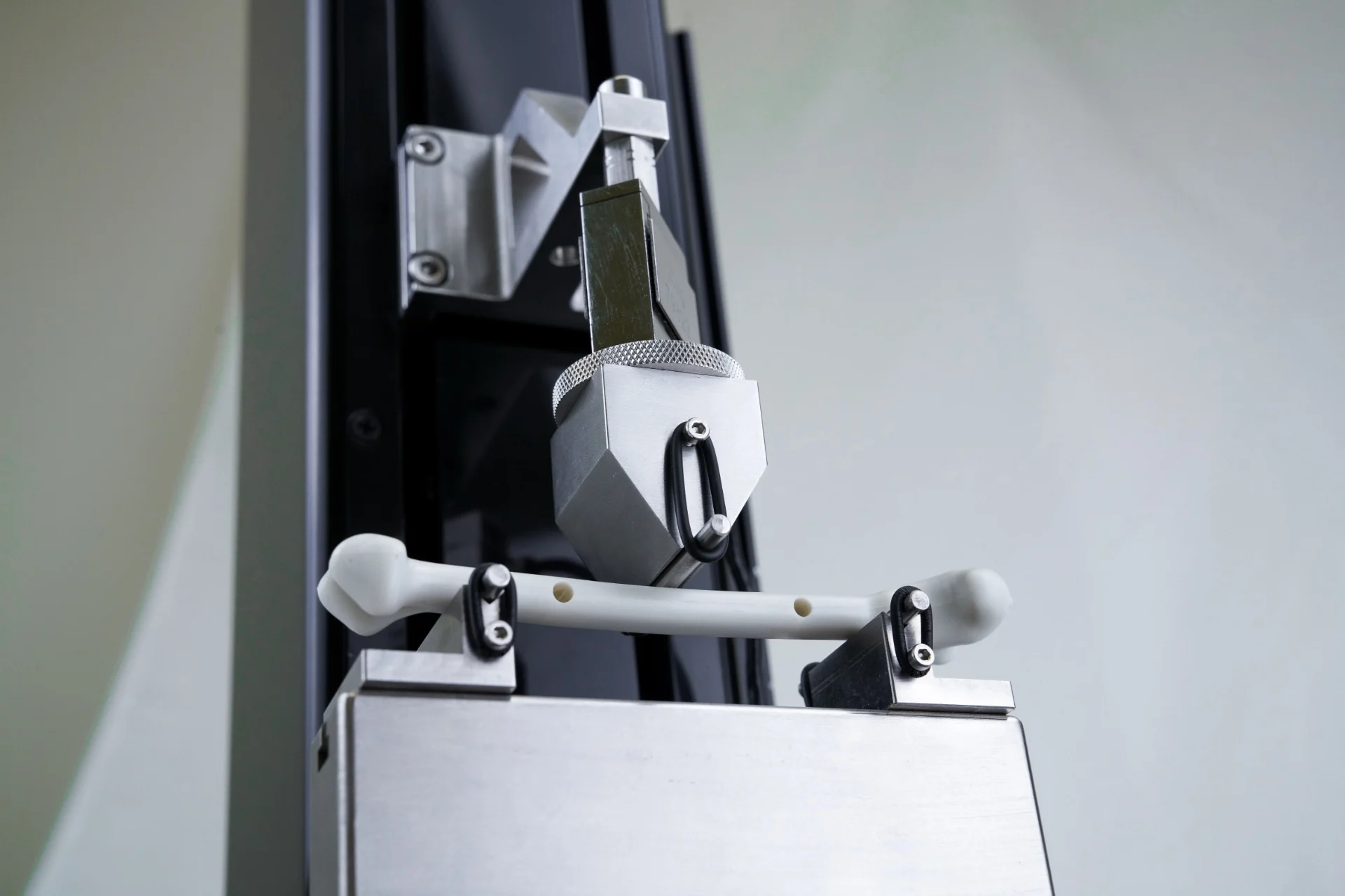 The UniVert uniaxial mechanical testing system with the flexural and bending fixture setup with bone specimen