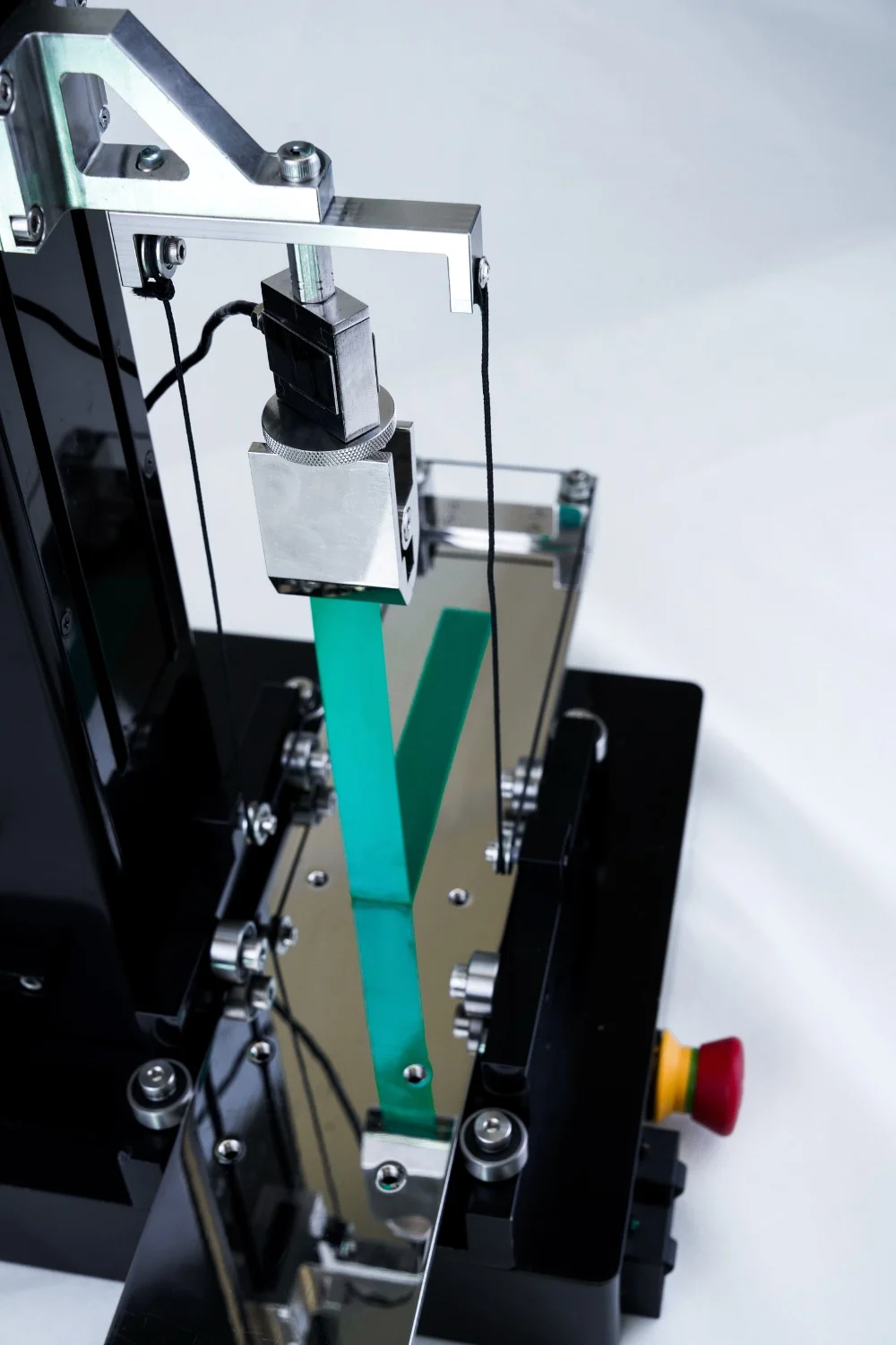 The UniVert mechanical tester setup with a peel test fixture and tape being peeled