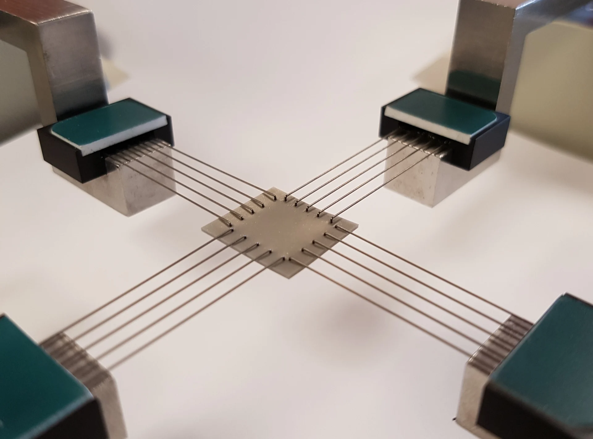 A square specimen being biaxially tested with BioRakes on the BioTester