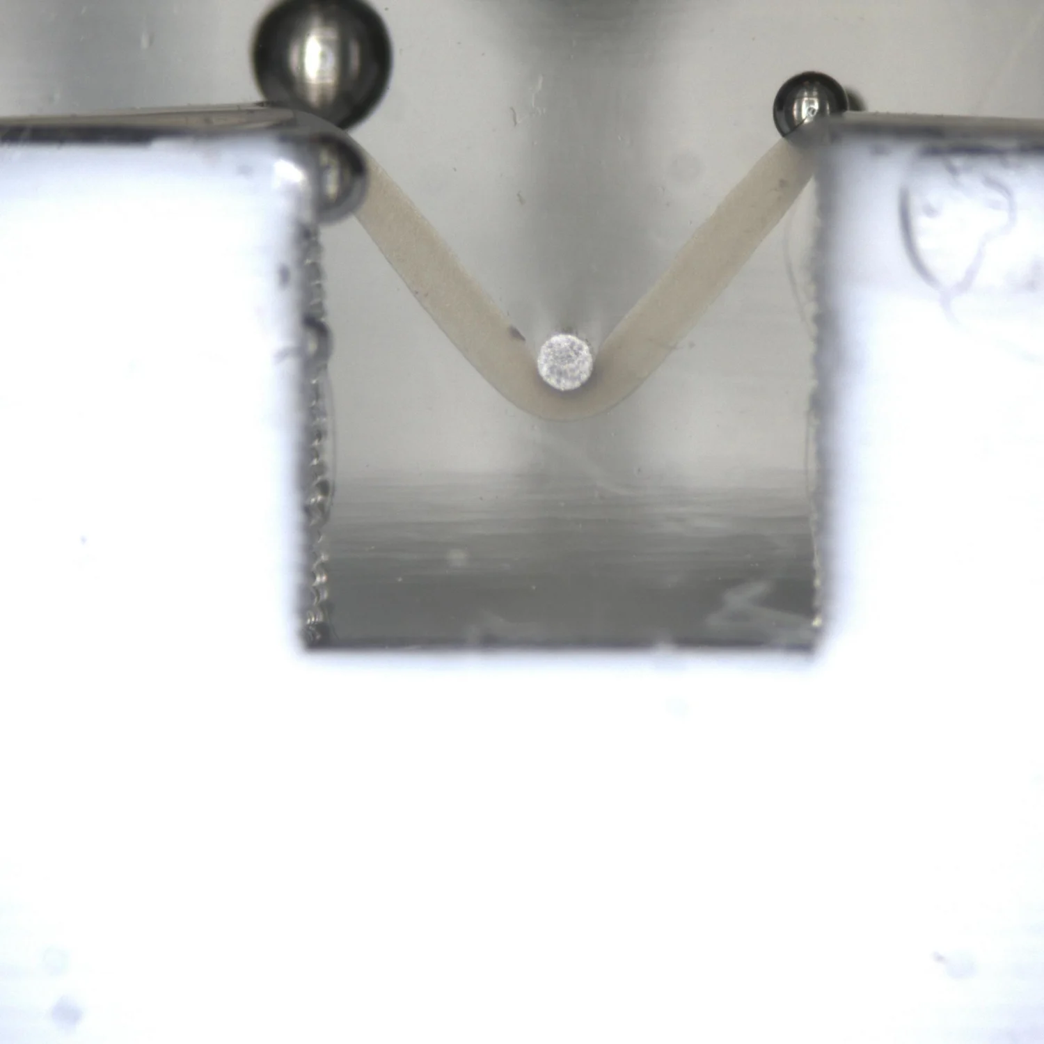 A fibre being 3 point tensile tested on the MicroTester