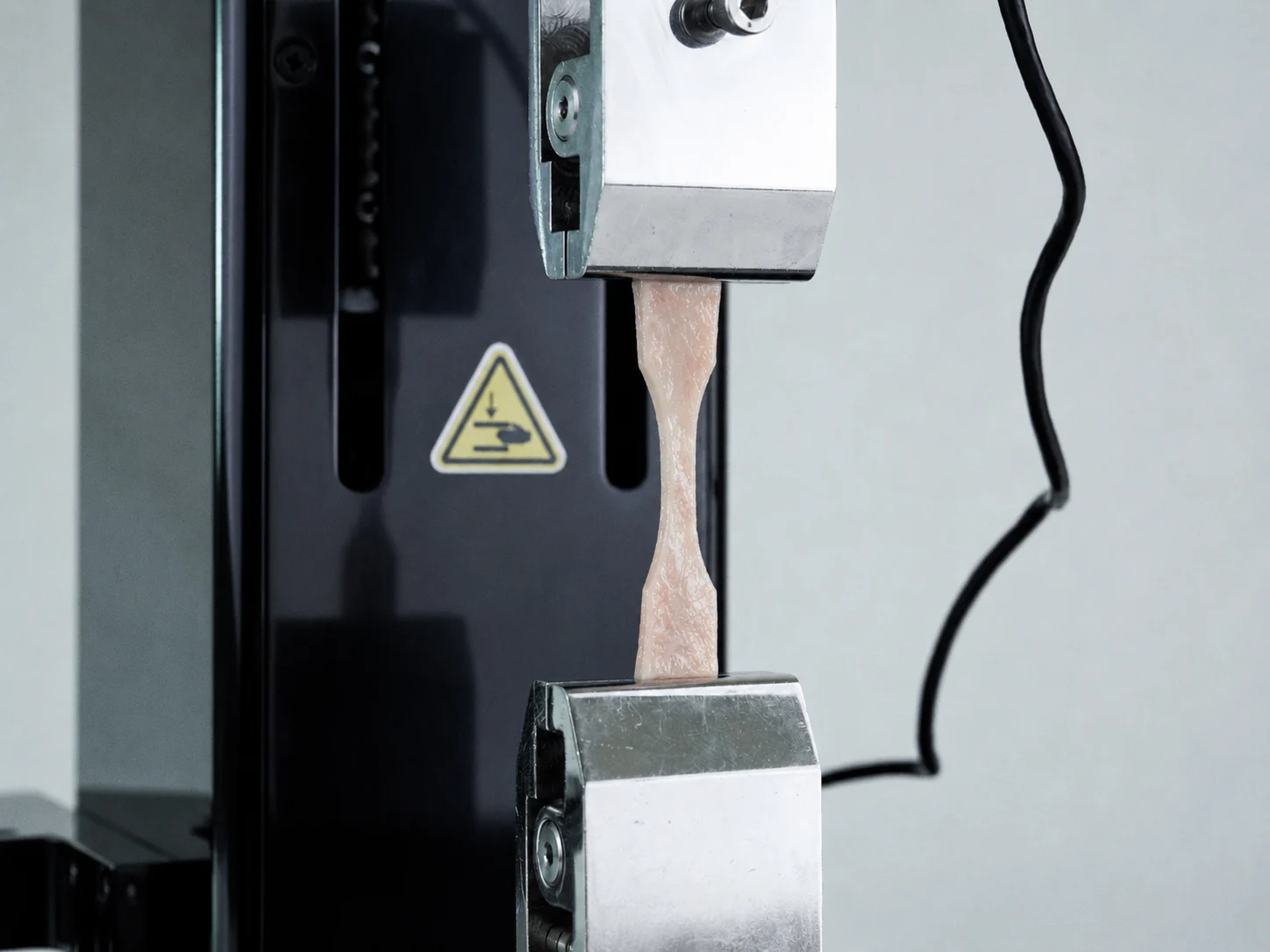 A dermal strip sample being tensile tested on the UniVert for skin biomechanics research