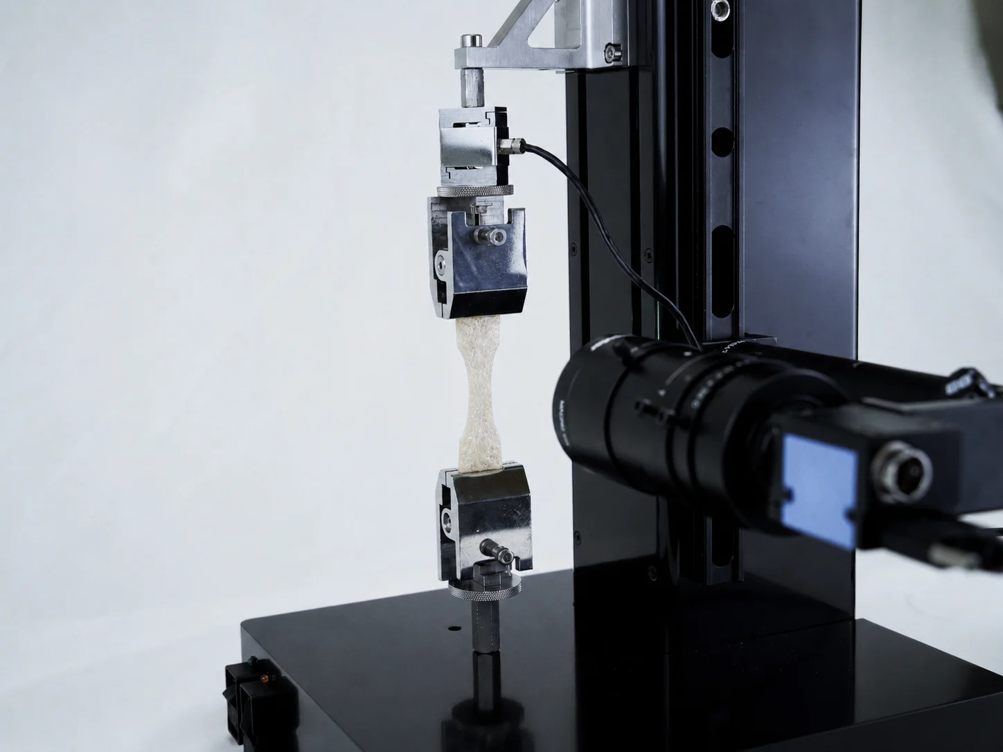 An ECM sheet being tensile tested on the UniVert for extracellular matrix mechanics research