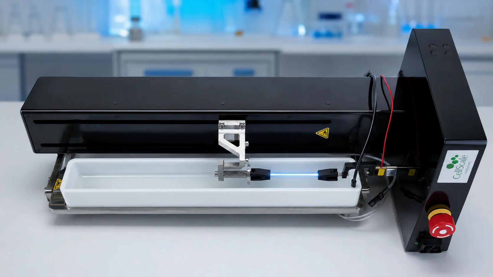 UniVert performing hydrated tensile testing on a glowing hydrogel optical fibre mounted between grips in a fluid bath.